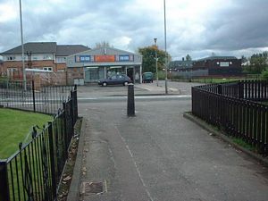 The path from Ailsa Road meets Old Monkland Road opposite the shop and the short road to the next path which goes between some pitches